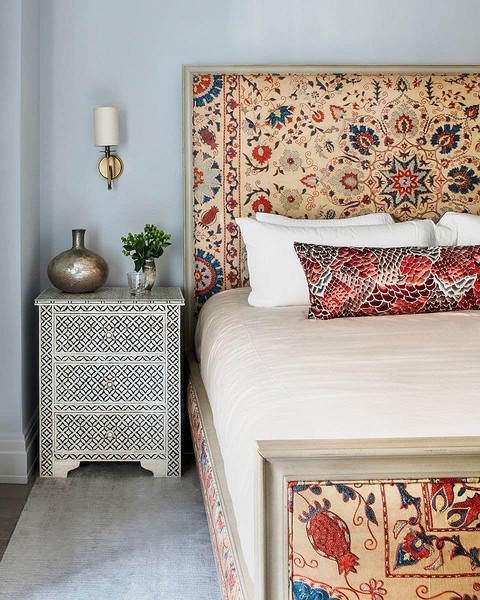 Сучасний дизайн спальні з ліжком з високим дерев'яним узголів'ям та стильним освітленням.