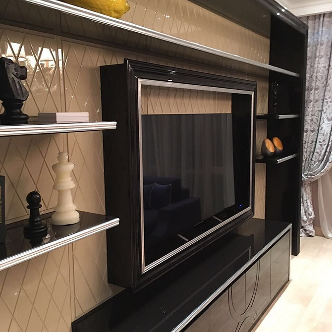 Ніша для телевізора з декоративним каміном, що додає тепла та елегантності вітальні.