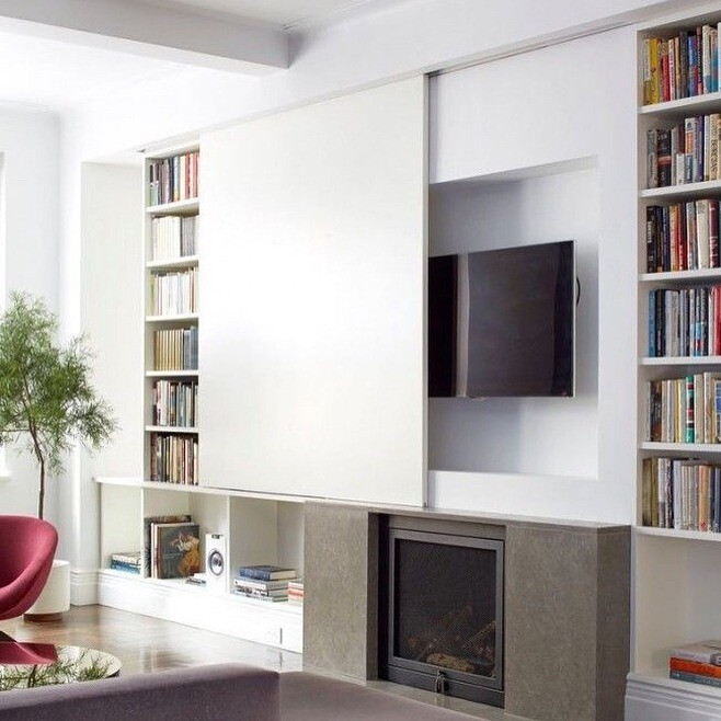 Функціональна ніша для телевізора з вбудованими шафами для зберігання речей та книг.