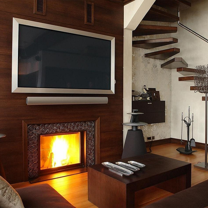 Простора вітальня з великим телевізором, вбудованим в нішу з гіпсокартону