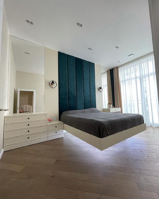 Затишна спальня з парячим ліжком та теплим освітленням, ідеальне місце для відпочинку.