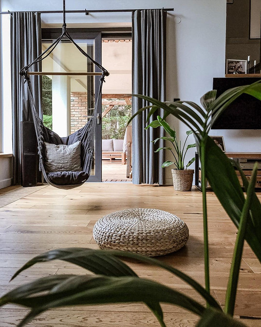 Підвісне крісло з ротангу в інтер'єрі вітальні: натуральний стиль та затишок.