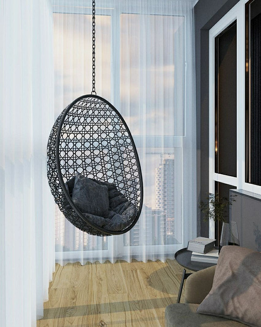 Підвісне крісло, оточене рослинами в інтер'єрі, створення зеленої оази для відпочинку.