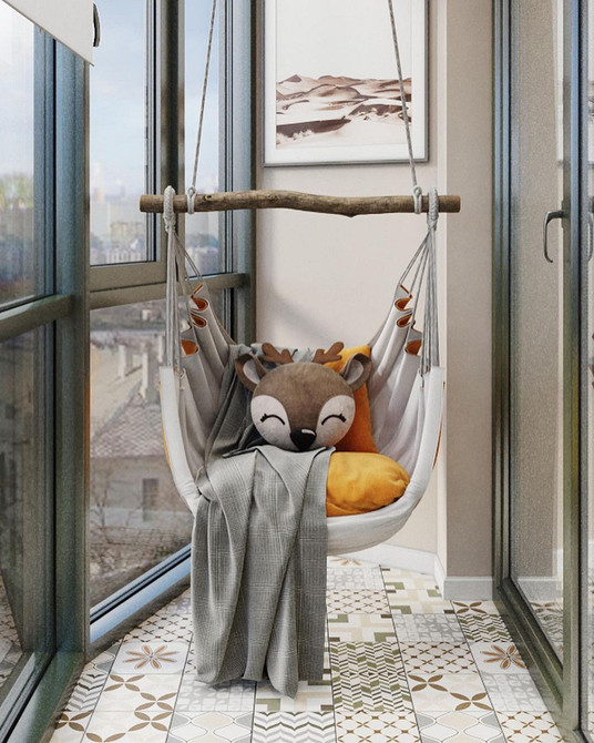 Елегантне підвісне крісло кокон в інтер'єрі спальні з подушками та пледом