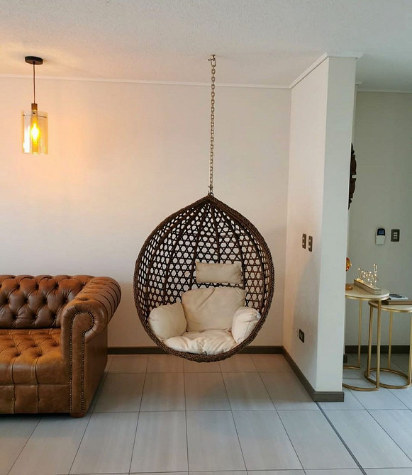 Підвісне крісло гамак з подушками в мінімалістичному інтер'єрі квартири