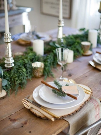 Різдвяний хвойний декор: святковий букет з ялинкових гілок, прикрашений різдвяними іграшками на столі.