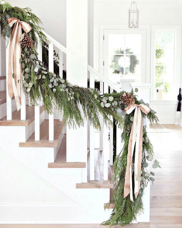 Різдвяні прикраси з хвої: гірлянда з ялинкових гілок над дверима.