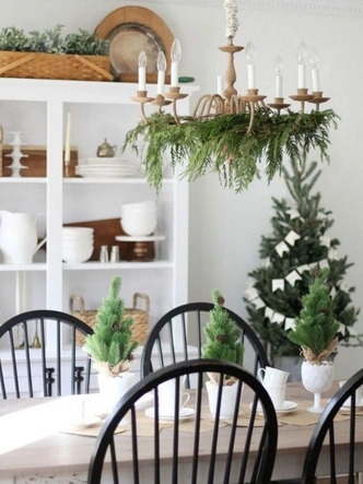 Різдвяний декор: композиція з ялинкових гілок, свічок і шишок на столі.