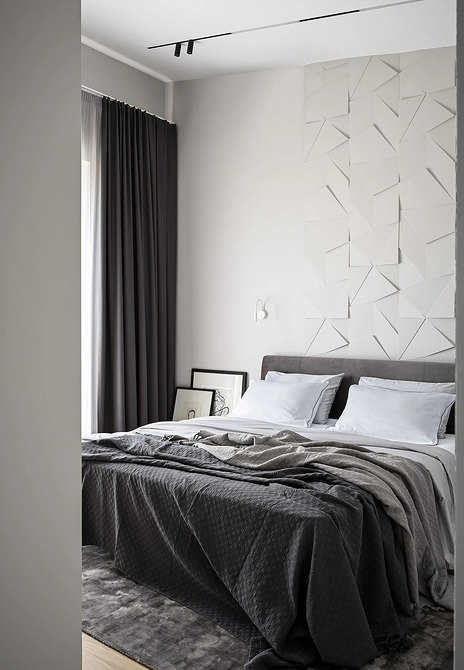 Мінімалістична спальня з сірим ліжком, тумбочкою та лаконічним декором.