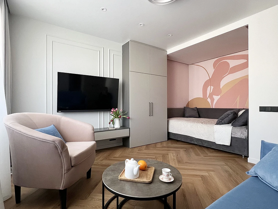 Простора спальня з сірою ліжком, тумбочками та декоративними подушками в тон.