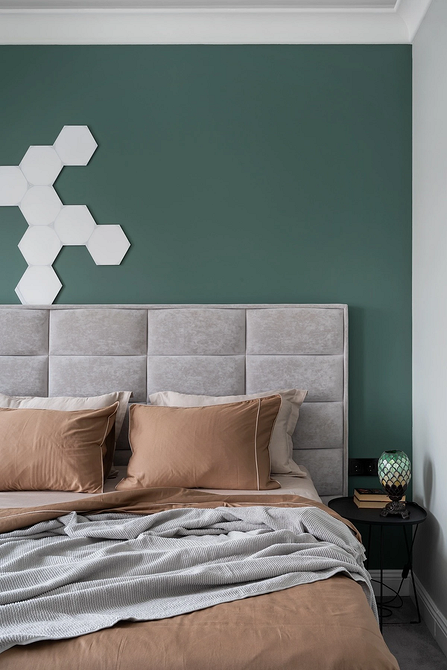 Сучасна спальня з сірим ліжком, великими вікнами та природним освітленням.