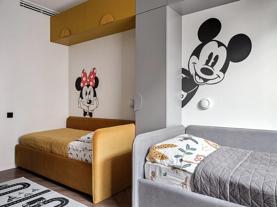 Інтер'єр невеликої спальні з компактним сірим ліжком та нічним освітленням.