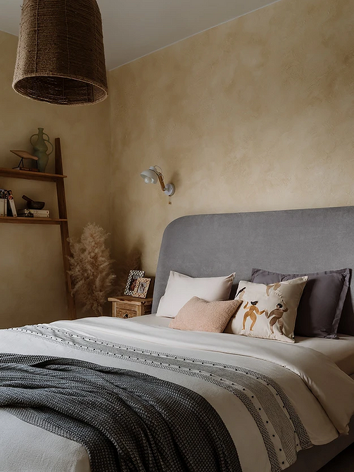 Сучасний дизайн спальні з сірим ліжком та білими стінами для затишку.