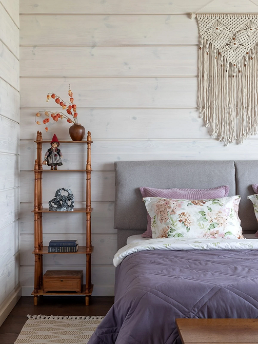 Світла спальня з сірим ліжком та великими вікнами, що забезпечують природне освітлення.