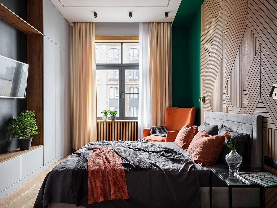 Затишна спальня в нейтральних кольорах з сірим ліжком та лляною постільною білизною.