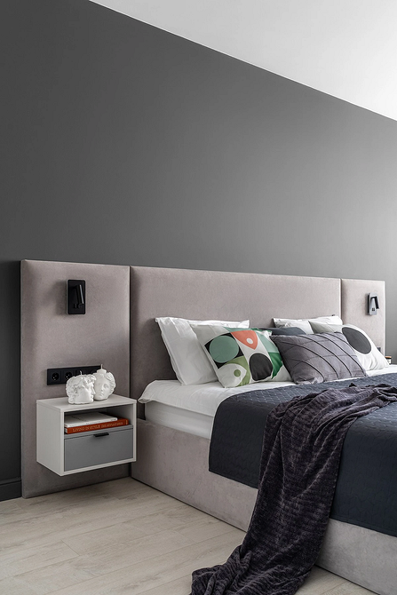 Сіра ліжко в скандинавському стилі в спальні з дерев'яними елементами та природним освітленням.