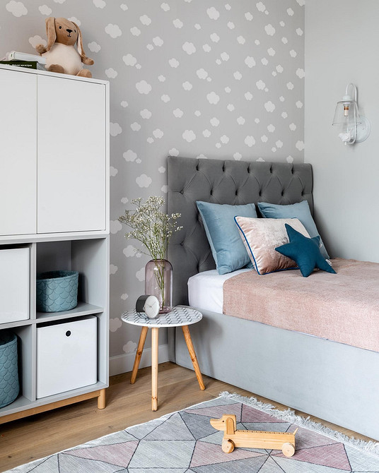 Дитяча кімната в сірих тонах з яскравими акцентами та іграшками.