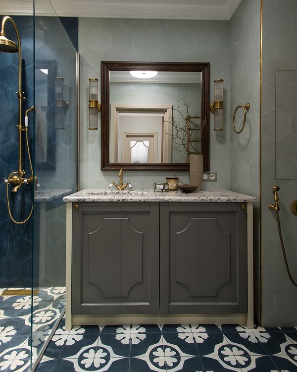 Сіра тумба під раковину в сучасній ванній кімнаті з дзеркалом.