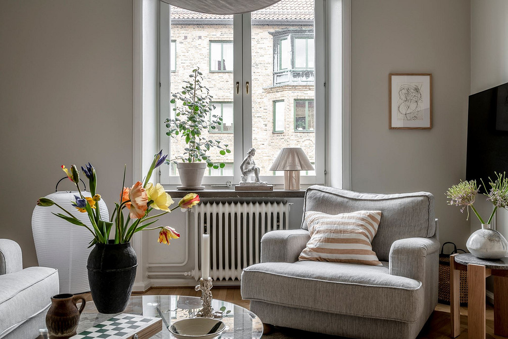 Світла сіра ванна кімната з сучасними меблями, що виглядає просторо та стильно.