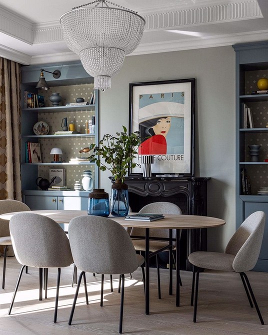 Вітальня з сірим кутовим диваном, поєднана з яскравими декоративними подушками та килимом.