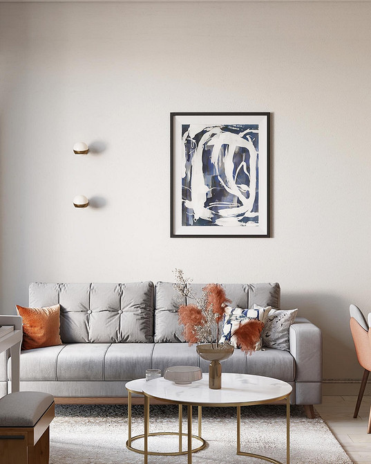 Затишний куточок з сірим диваном, пледом і книжковою полицею.