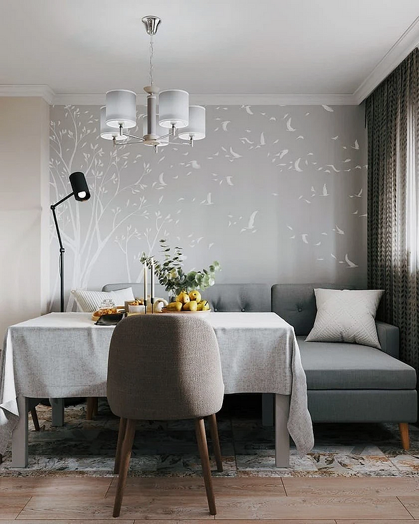 Сучасний сірий диван в інтер'єрі вітальні з яскравими акцентами та декором.