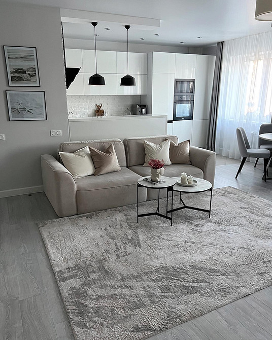 Стильний інтер'єр з сірим диваном, каміном та декоративними елементами.