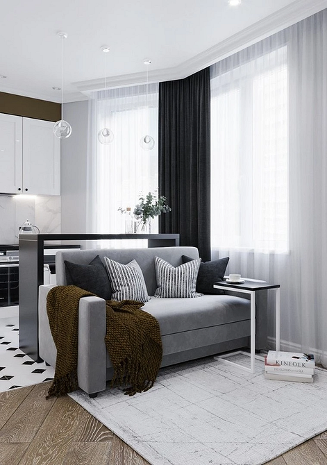 Інтер'єр з сірим диваном, дерев'яним столиком та килимом у світлій вітальні.