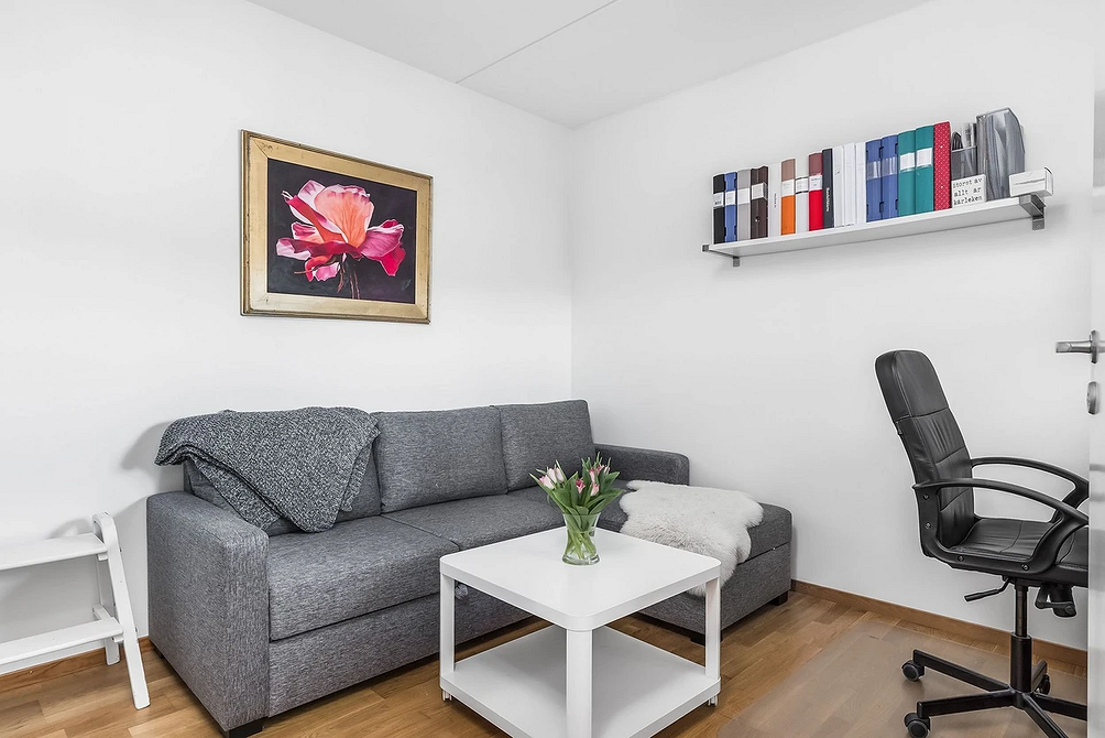 Модульний сірий диван у великій вітальні з каміном та великим телевізором.