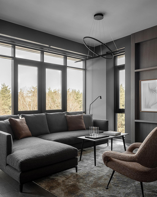 Сучасний сірий диван в інтер'єрі з яскравими акцентами та декоративним текстилем