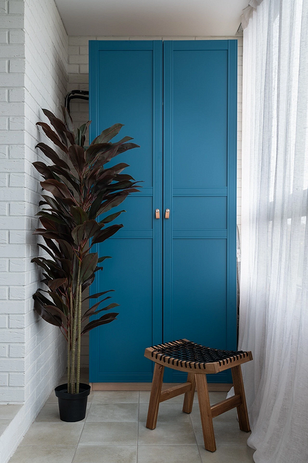 Приклад облаштування балкона з шафою для зберігання речей та організації простору.