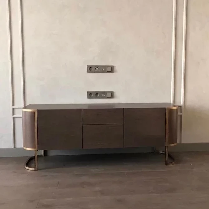 Низький комод під телевізор у спальні для зберігання речей та створення затишної атмосфери.