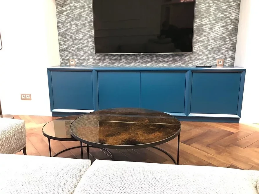 Стильна вітальня з низькою тумбою під телевізор для зберігання та розміщення техніки.