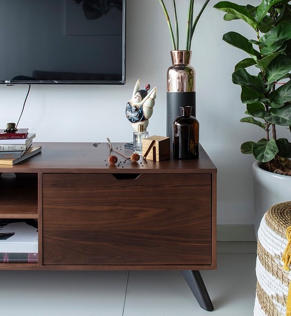 Тумба під телевізор з глянцевими фасадами в сучасній вітальні.