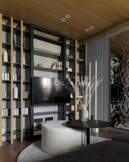 Велика шафа-купе під телевізор у вітальні з інтегрованим освітленням.