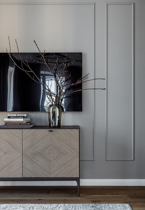 Світла тумба під телевізор з акцентною стіною у вітальні з м'яким освітленням.