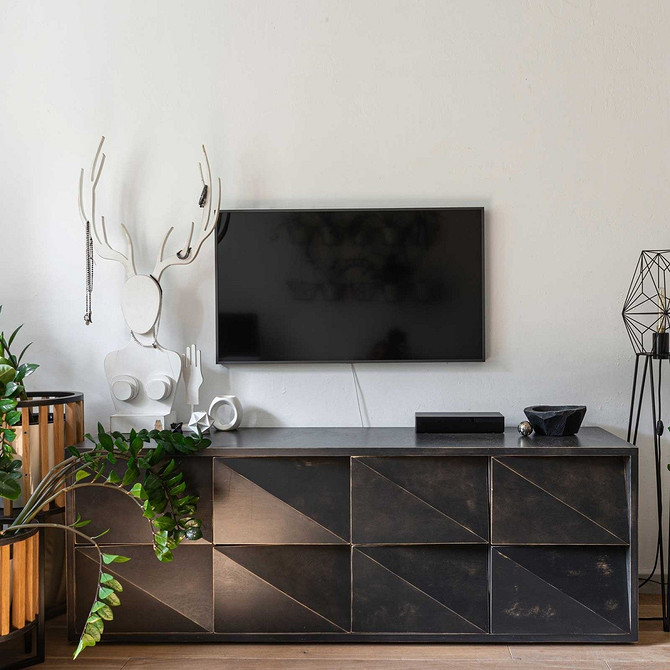 Інтер'єр вітальні з низьким комодом під телевізор для зберігання та декору.