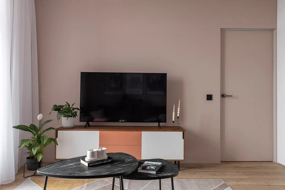 Елегантна шафа для телевізора з скляними дверцятами у класичному інтер'єрі.