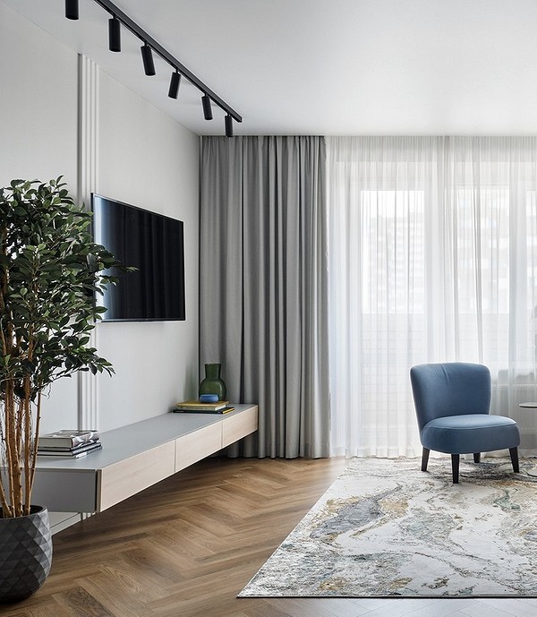 Сучасна вітальня з білою тумбою під телевізор та декоративними елементами.