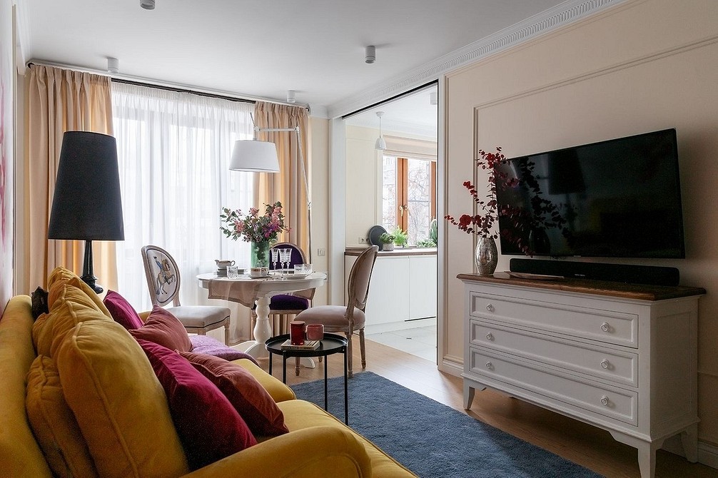 Тумба під телевізор з відкритими полицями та декоративними рослинами у вітальні.