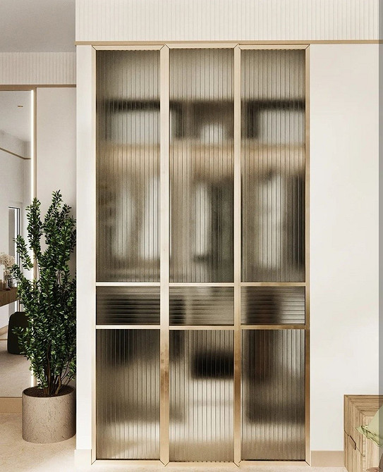 Елегантна шафа-купе з матовими скляними дверцятами в інтер'єрі сучасної спальні.