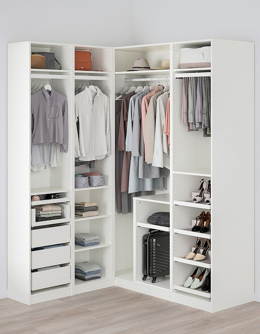 Простора шафа-купе з різними секціями для одягу, взуття та аксесуарів у спальні