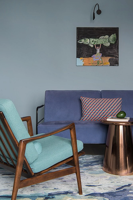 Світла вітальня з синім диваном, великим вікном та дерев'яною підлогою