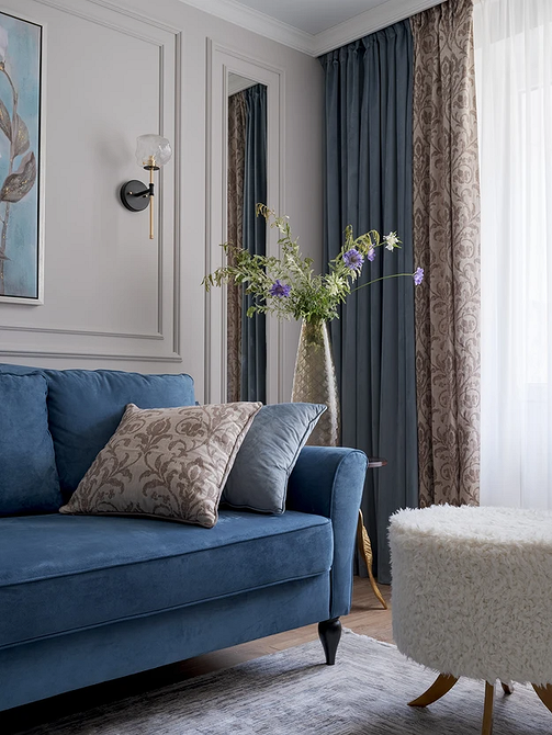 Синій шкіряний диван в офісному інтер'єрі з металевими елементами декору.