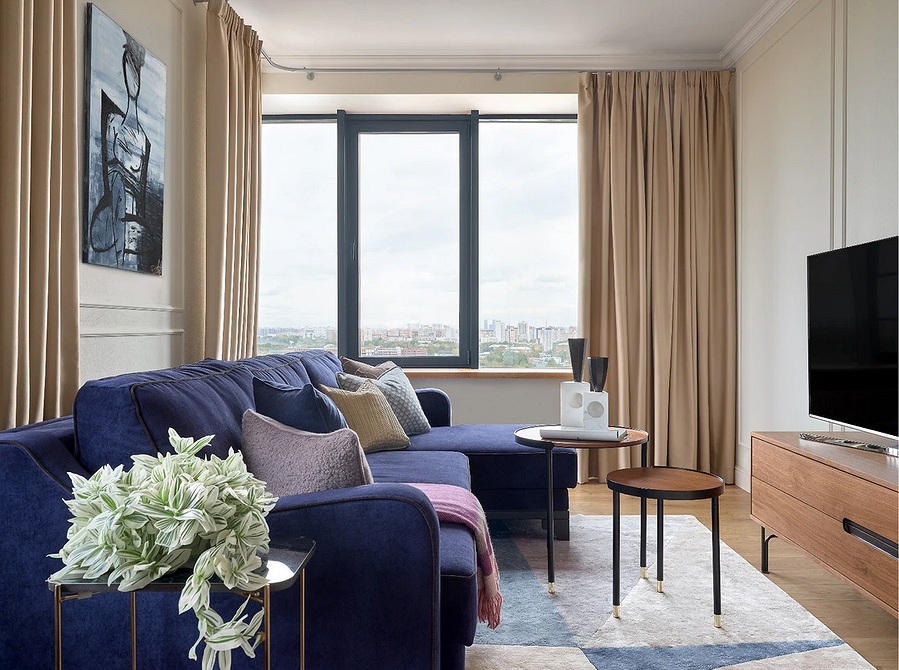 Елегантний інтер'єр з синім велюровим диваном та золотими деталями