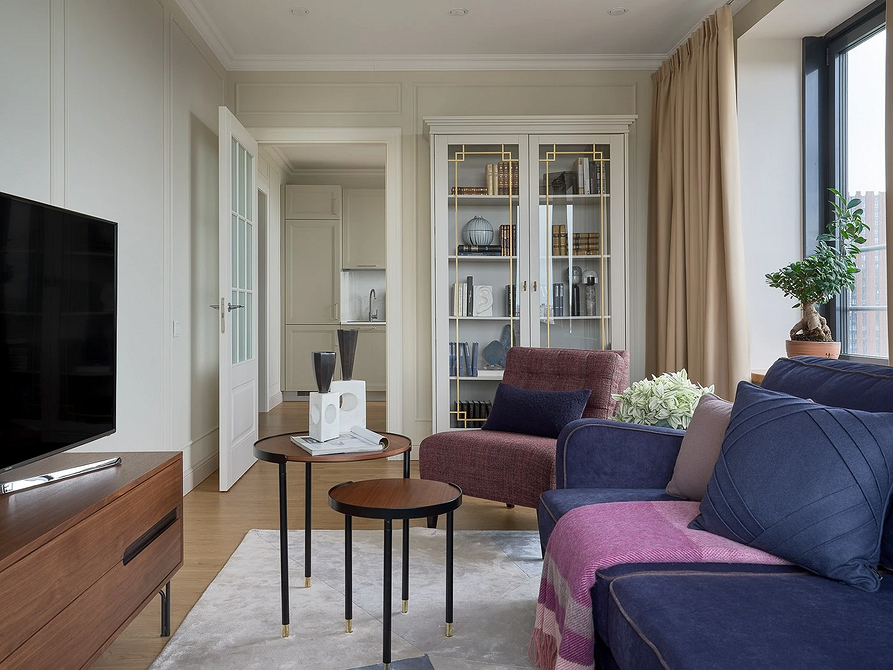 Синій диван в інтер'єрі з білими стінами та рослинами у горщиках