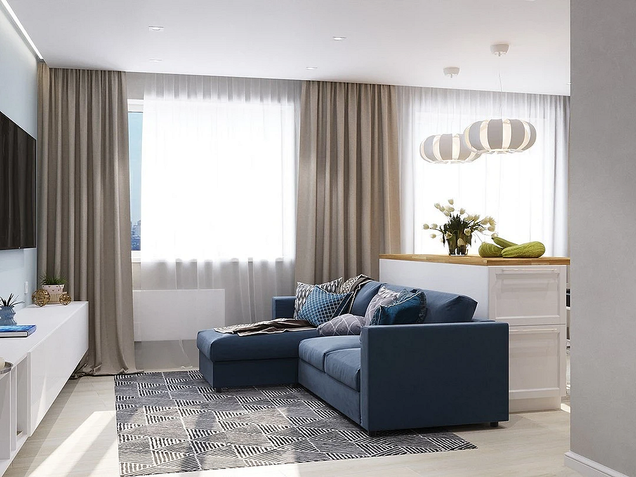 Світла вітальня з синім диваном, килимом з геометричним малюнком та великим вікном.