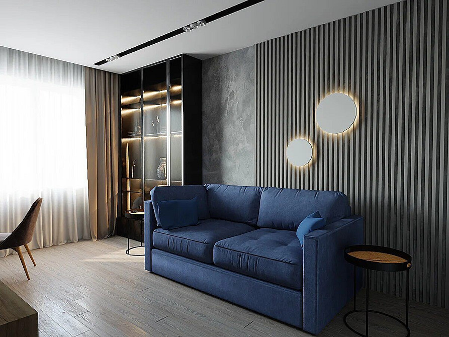 Дизайн інтер'єру з синім диваном: поєднання меблів та стін для створення затишку.