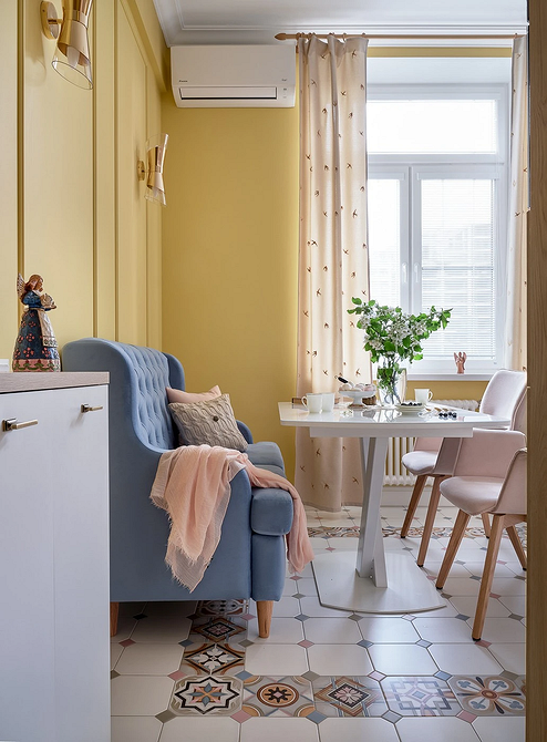 Дизайн вітальні з синім диваном, декоративні подушки та килим у поєднанні з синім