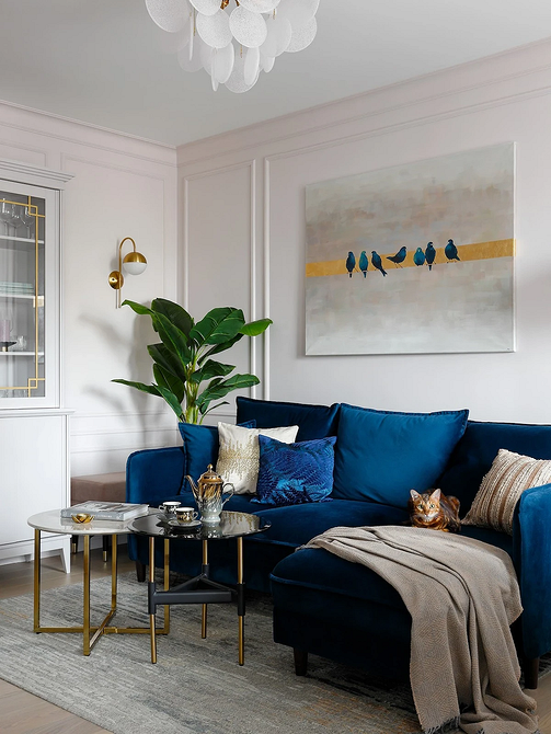 Сучасний синій кутовий диван у вітальні з панорамними вікнами та мінімалістичним декором.